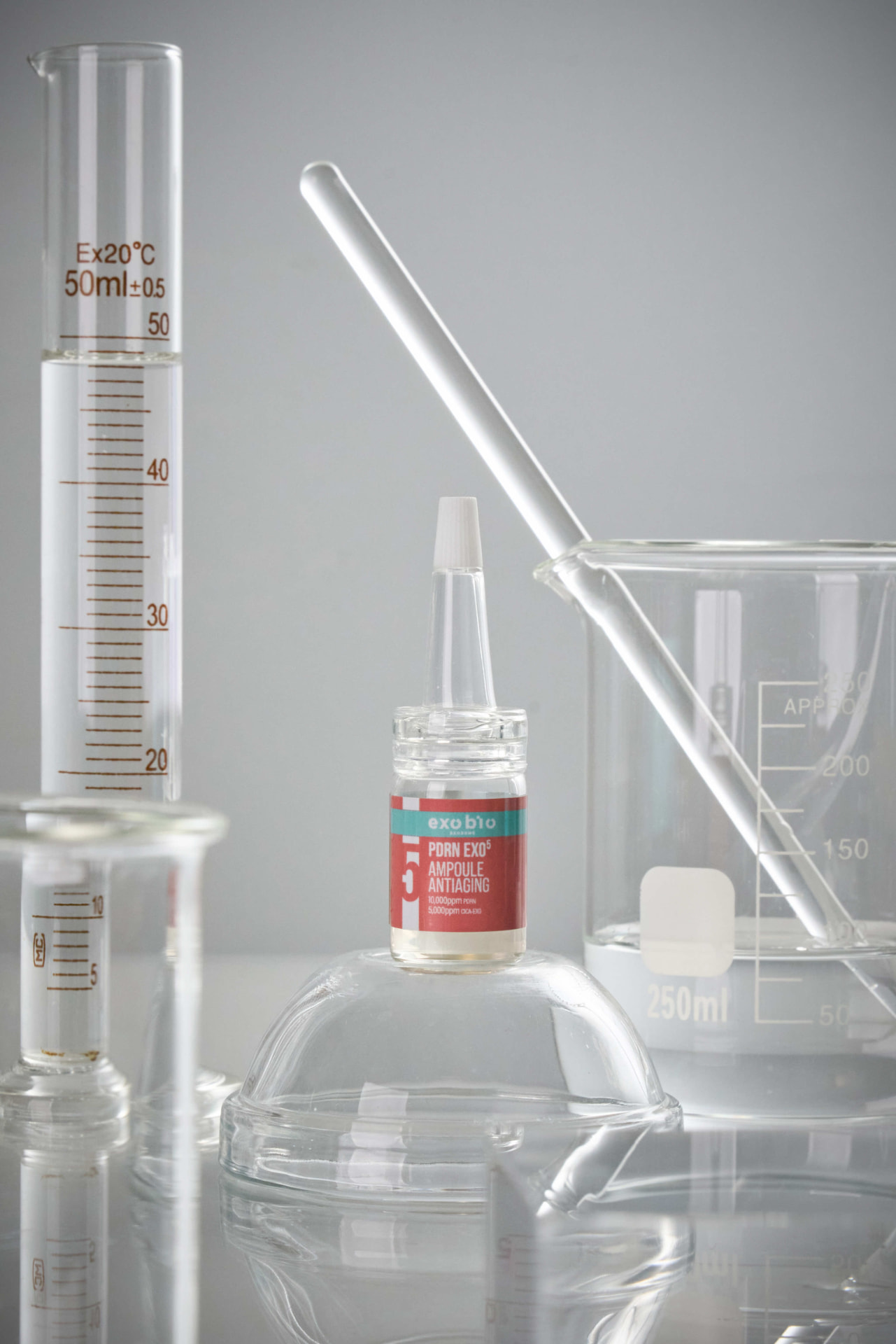 PDRN EXO5 Anti-Aging Ampulle mit rotem Etikett zwischen Laborglas